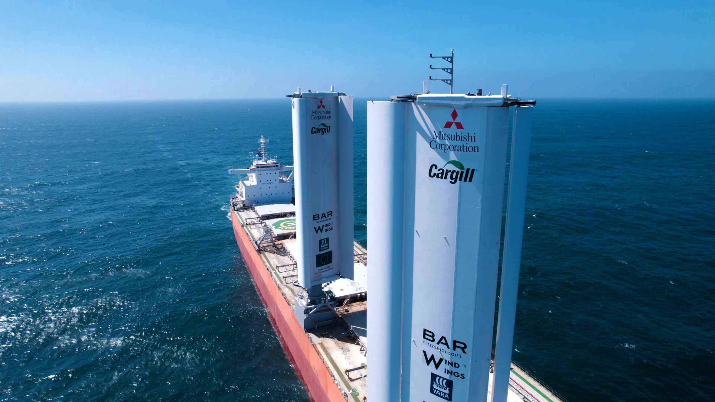 Un buque de carga comercial equipado con propulsión asistida por el viento navega cerca de un puerto europeo.
